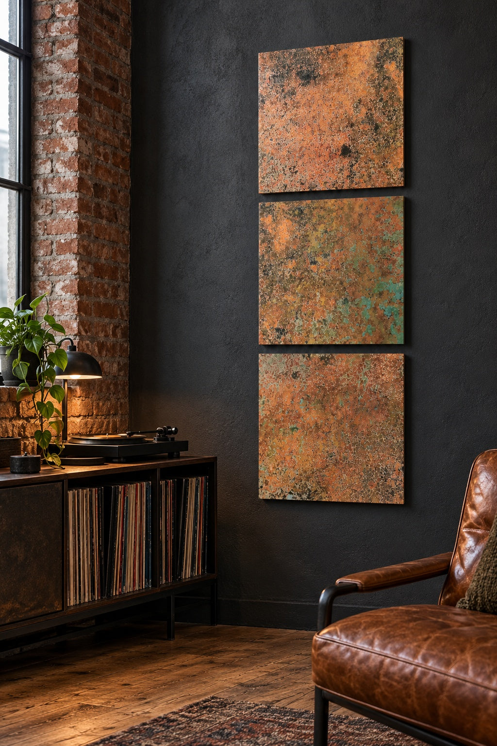 Mystic Copper Nebula – 3 miedziane panele w pionie na grafitowej ścianie loftu obok skórzanego fotela