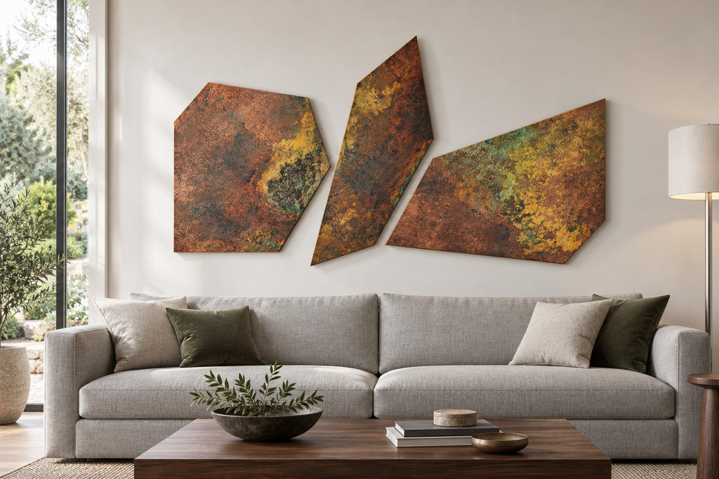 Copper Fragments Savage Copper Bloom – 3 nieregularne panele z miedzi z rdzawo-złotą patyną nad szarą sofą w salonie, wizualizacja aranżacji